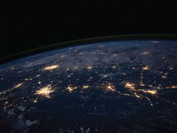 Photo of the earth at night from space that shows light pollution in cities.