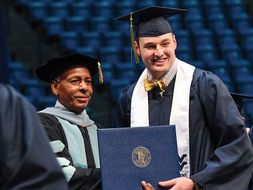 Matthew Bezjack accepting his diploma from Dean Brooks
