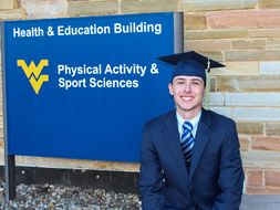 Ryan Stamski sport management graduation photo at CPASS building.