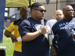 Jihad Dixon stands and speaks into a microphone at a WVU event.