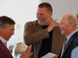CPASS professor Gary Lhotsky laughs in the presence of two other men