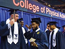 Logan Routt talks with other CPASS graduates during commencement
