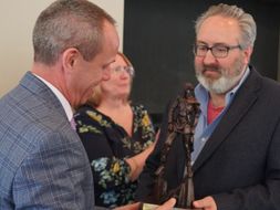 CPASS Associate Dean Sean Bulger presents Dean Jack Watson a mountaineer statue