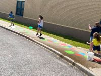 students hopscotch on sidewalk