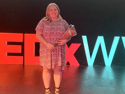 Lauren Marquart stands with flowers on the TEDxWVU stage