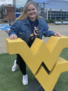 Lauren Marquart stands next to a flying WV