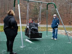 Family members try new adaptive swing in Kanawha State Forest.