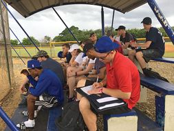 students taking notes at baseball game