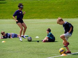 Young athletes practicing soccer with coach.