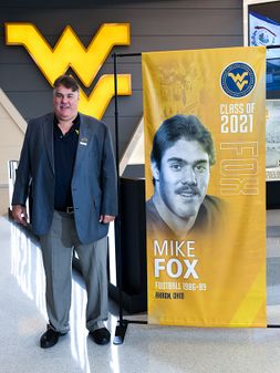 Mike Fox Standing beside his banner